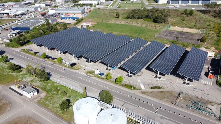 Rangées d'ombrières photovoltaïques sur un parking de zone d'activité, Drôme